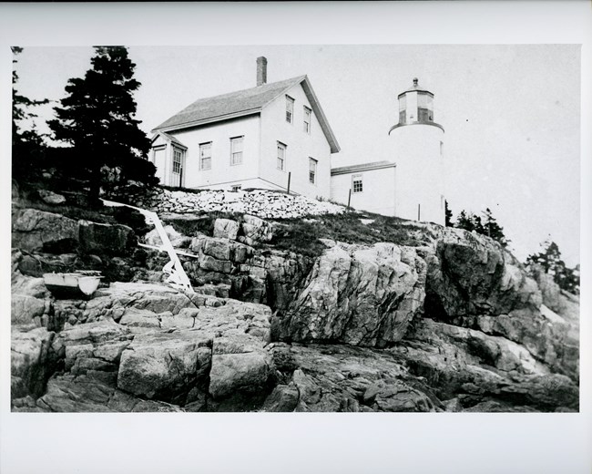Historic photograph of lighthouse on rugged coastline