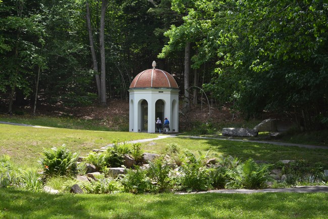 Structure over spring with two visitors looking in