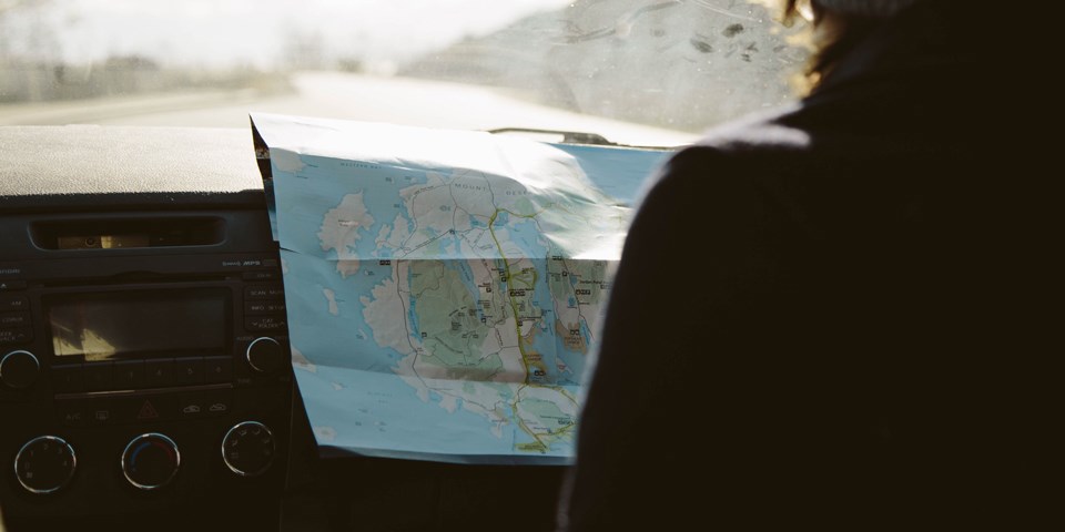 Visitor spreads park map across car dashboard Visitor spreads park map across car dashboard
