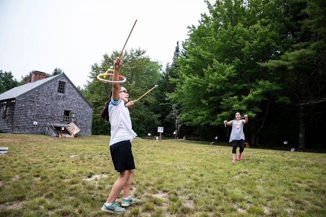 children play outside of a historic homestead