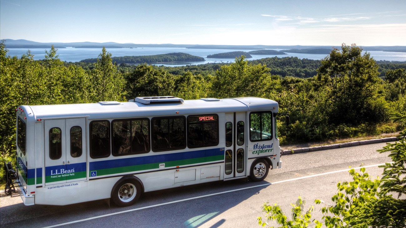 White shuttle bus park on road along Acadia coastline