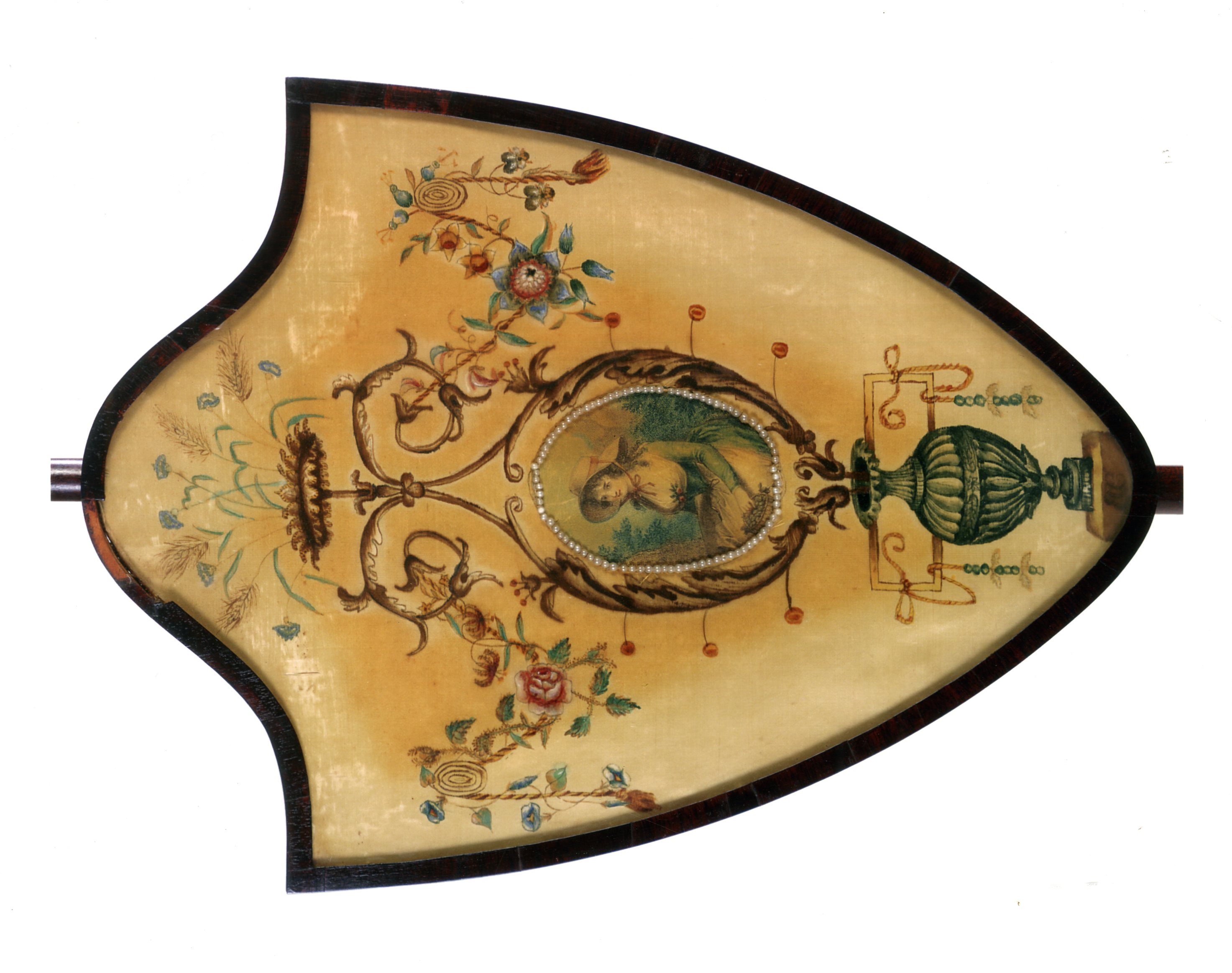 The silk shield-shaped screen has delicate hand painted images of an urn, flourishes, garlands, and flowers all surrounding a center image of a woman sitting in a garden. 