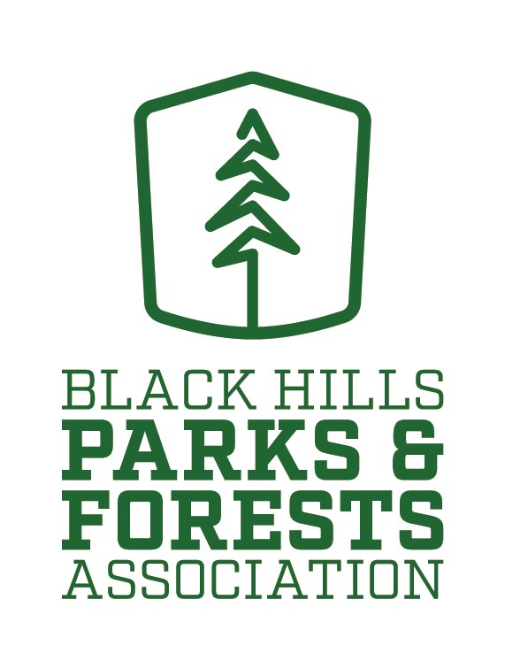A logo featuring a stylized pine tree above text that reads Black Hills Parks and Forests Association.