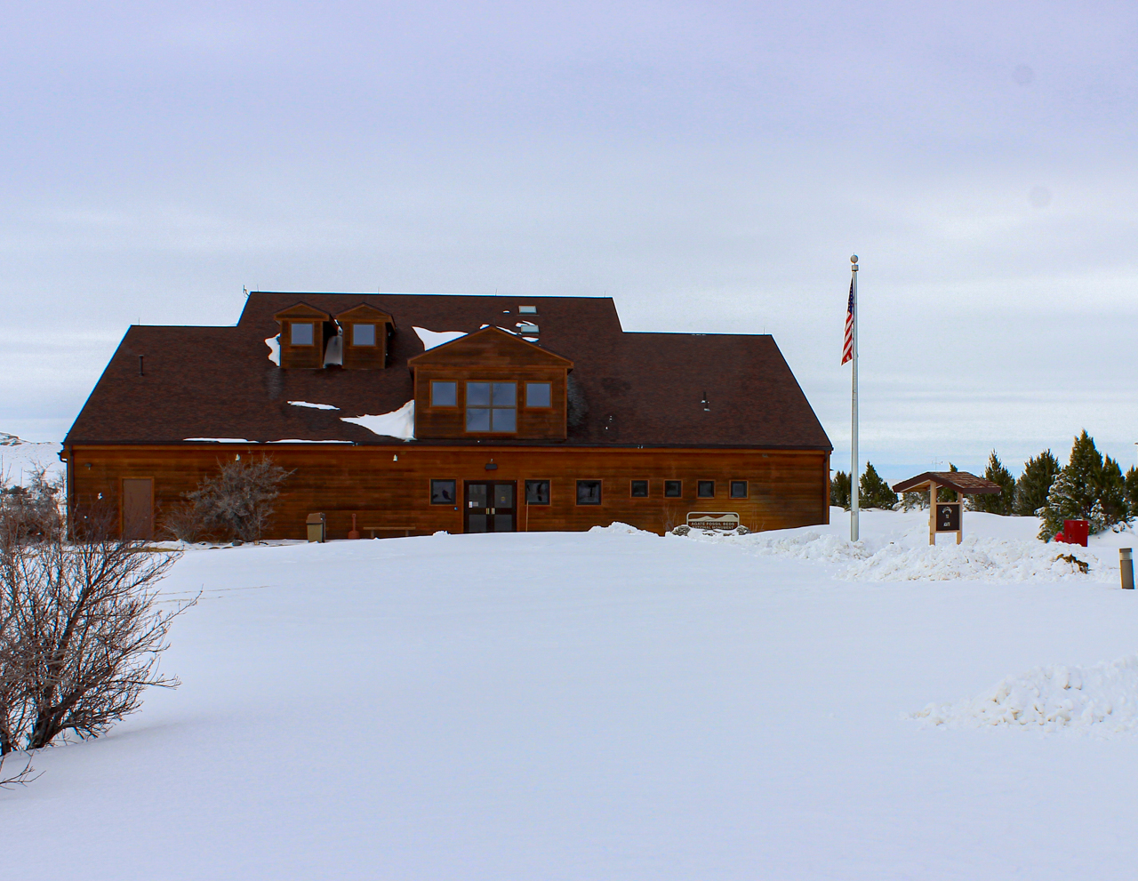 Brown building and american flag in deep snow