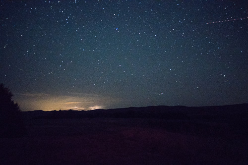 Night sky with shooting star Photo of night sky with shooting star and sunset light on horizon.