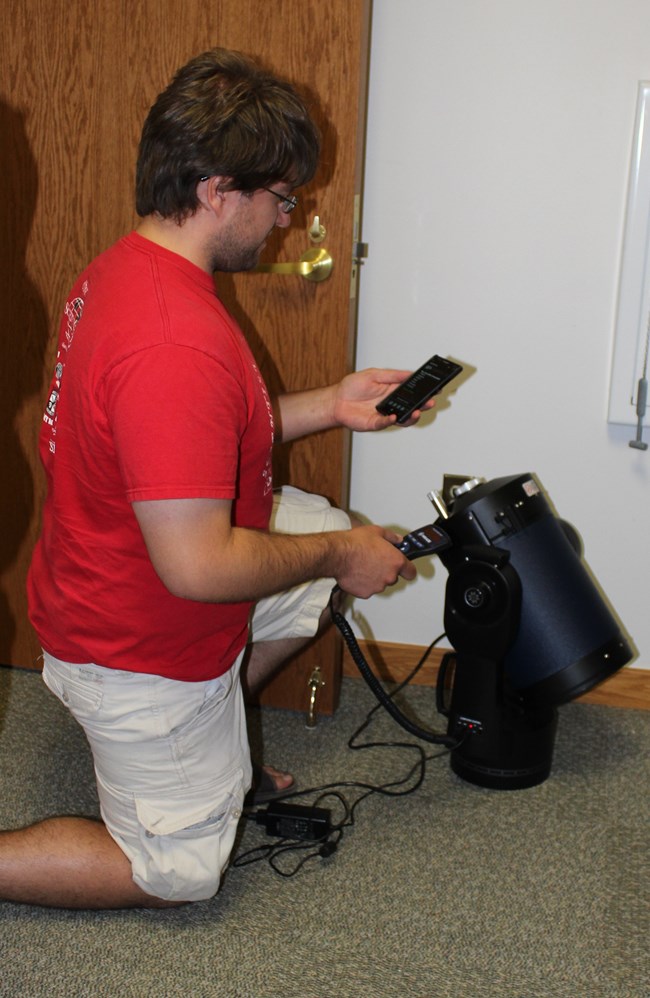 Amateur astronomer working on a telescope. This amateur astronomer is working on a telescope.