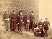 woman and soldiers in uniform sitting at base of building