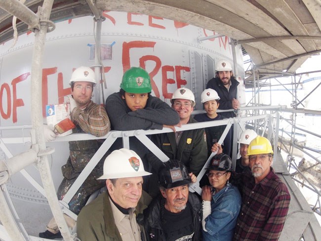 a group of people with hard hats holding paint cans a group of people with hard hats holding paint cans