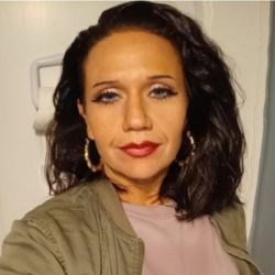 Woman with short brown hair takes selfie.