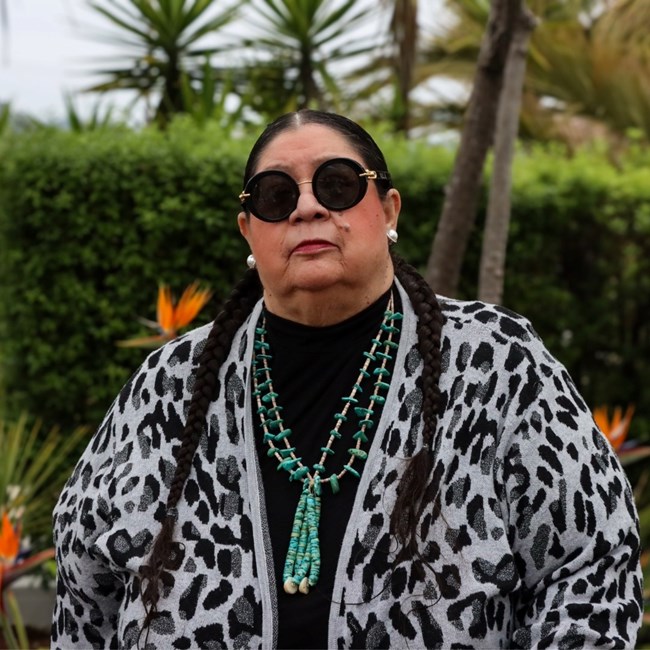 Portrait of woman with braids, sunglasses and beaded necklace