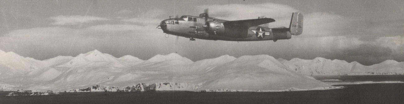 a historic scene of a propeller plane with a large star flying over a snowy coastal mountain range.
