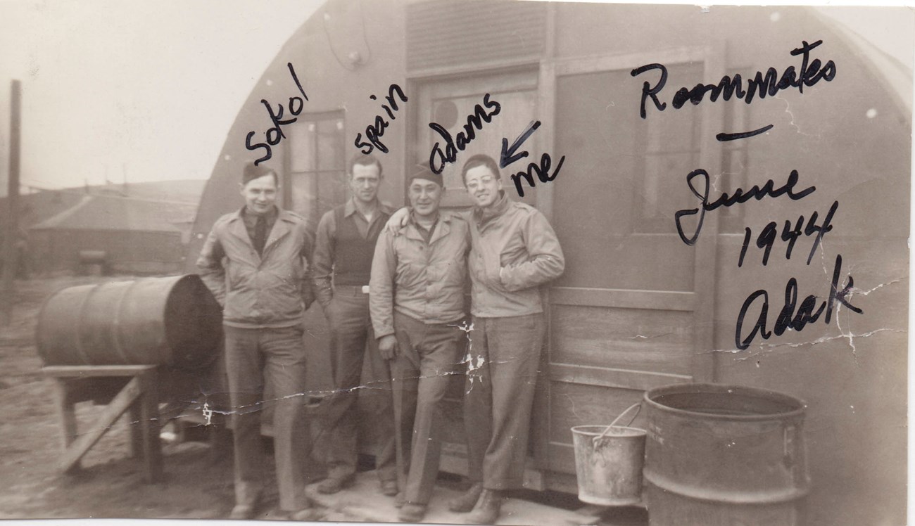 Al Martin and roomates Four men pose in front of a quonset hut. Handwritten text says Roommates June 1944 Adak and labels men left to right Sokol, Spain, Adams, me