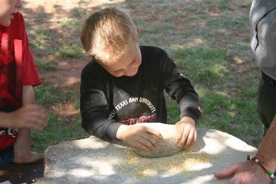 Grinding corn on a metate.