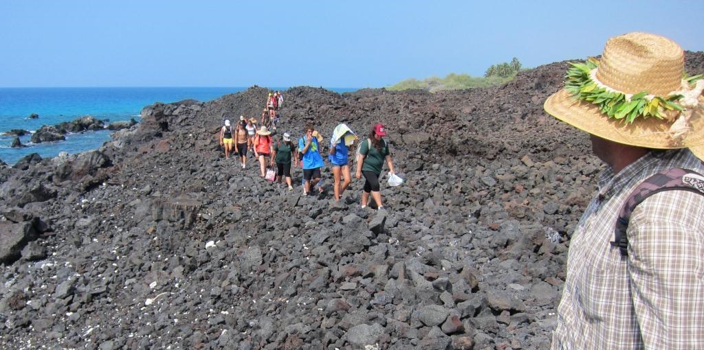 Youth and sponsors walk along on the rocky trail