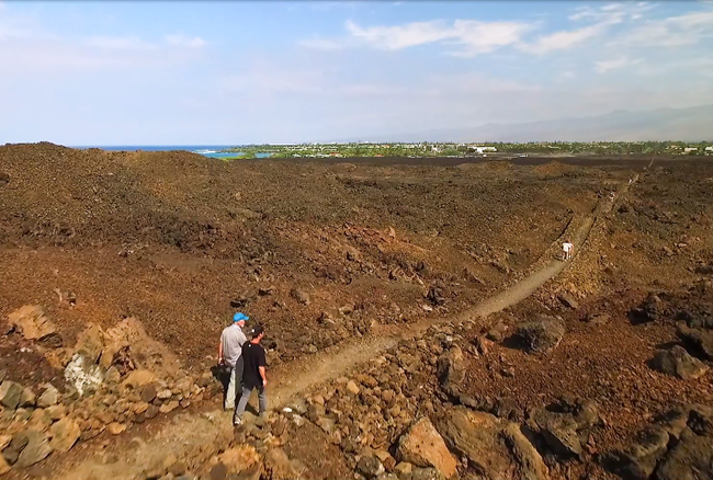 Hikers walking along straight and narrow segment of trail