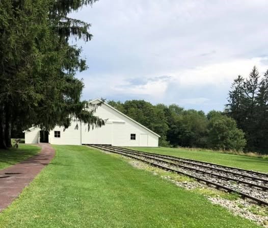 A white structure sits along railroad tracks.