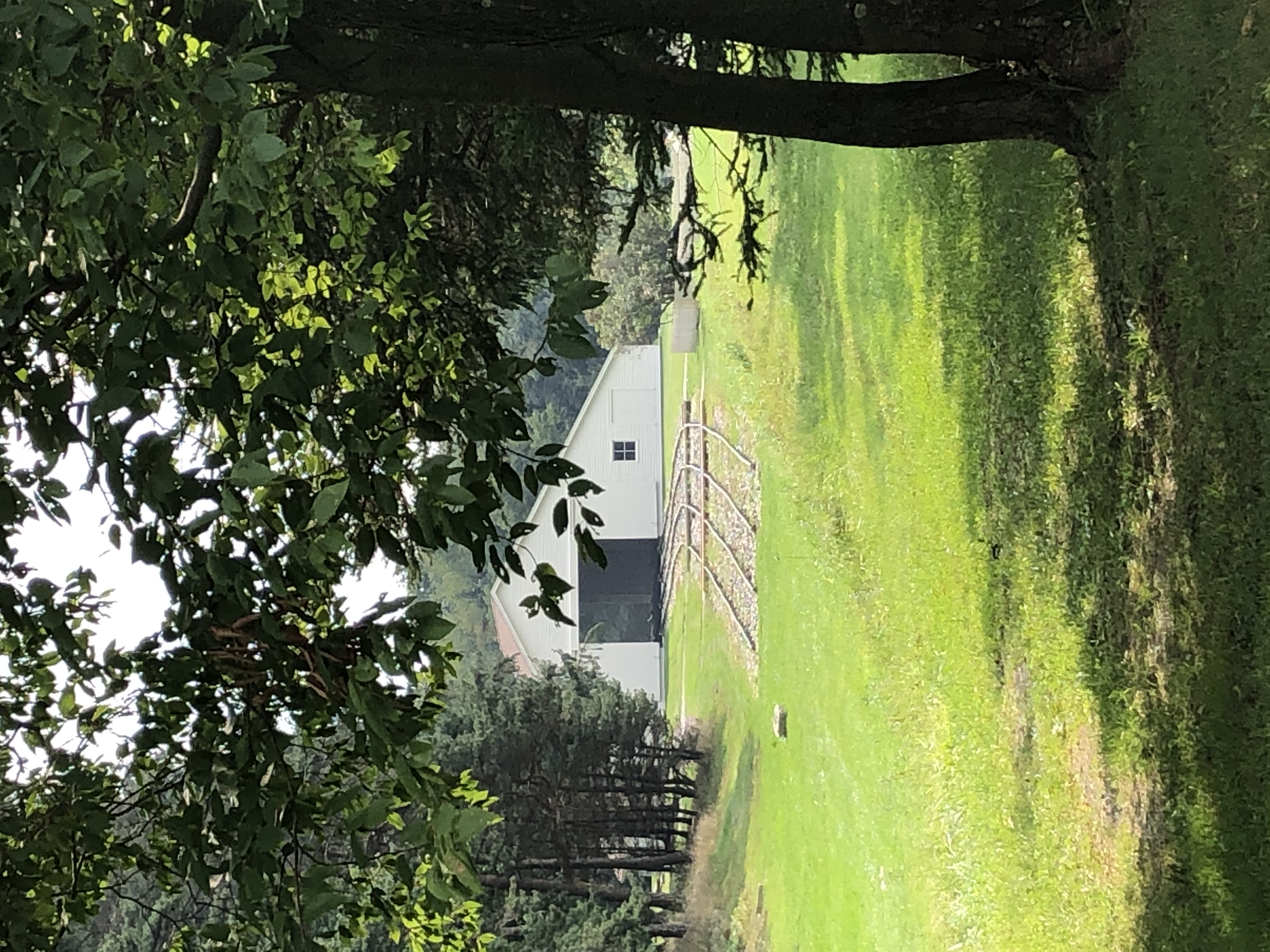 The engine house structure with railroad tracks and trace in front of it.