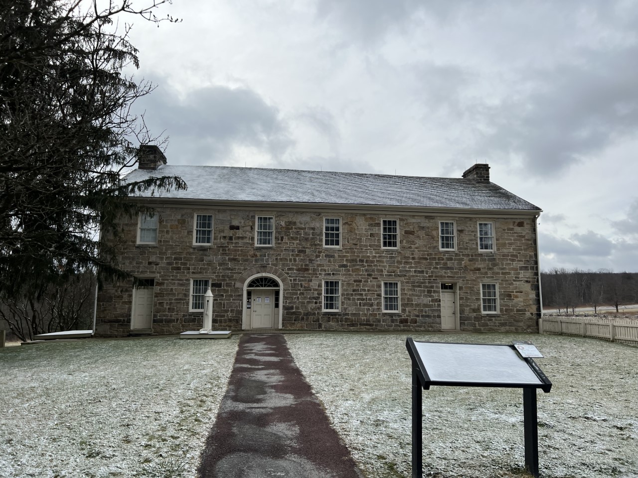 A two story stone tavern with snow.