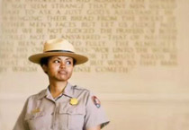 A female park ranger standing in front of monument