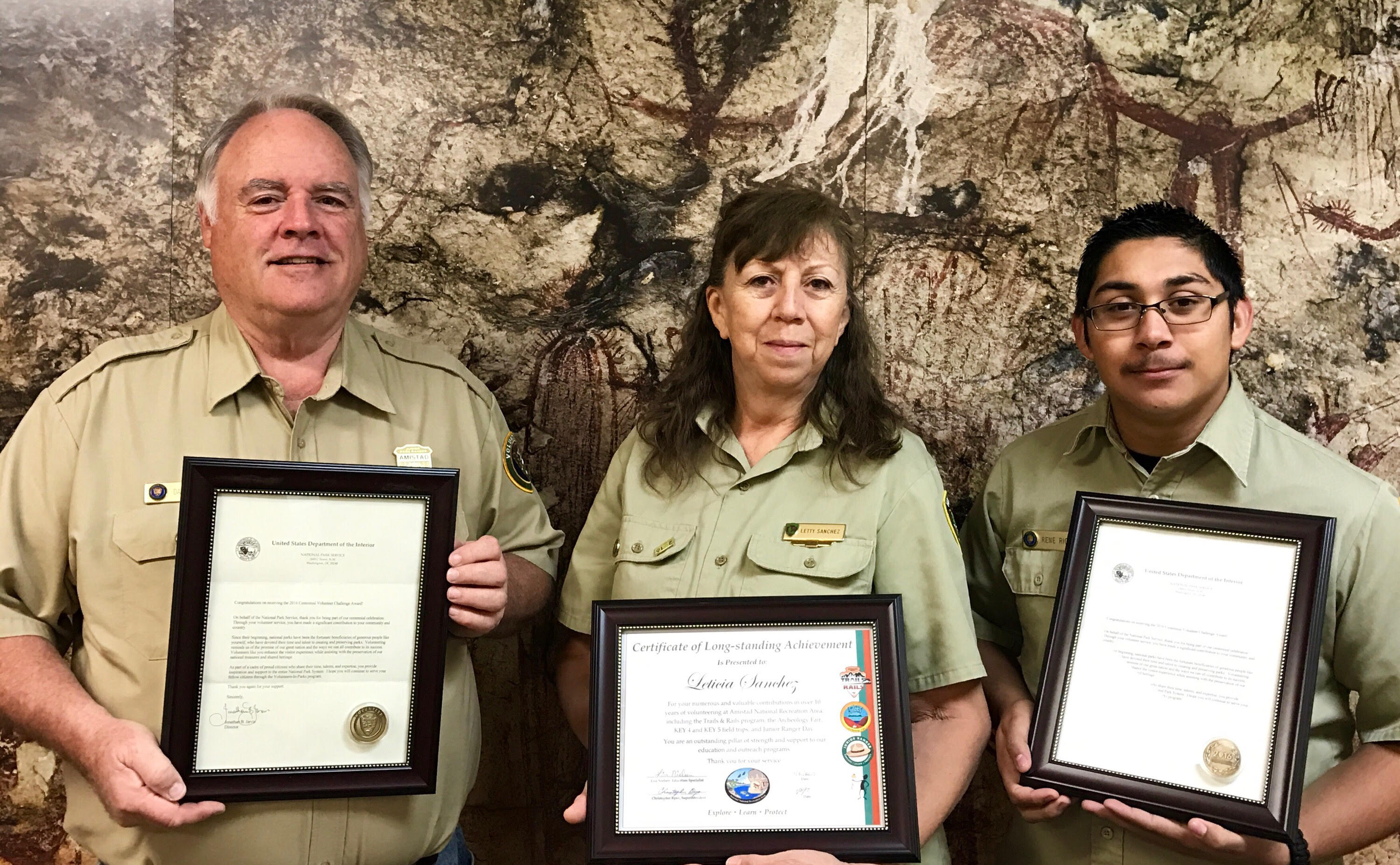 Volunteers pose with awards for their service.