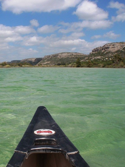 Nose of a kayak with waters of Amistad reservoir in front.