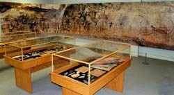 Replica of Native American artifacts in exhibit cases and scaled wall photograph of rock art. Replica of Native American artifacts in exhibit cases and scaled wall photograph of rock art.