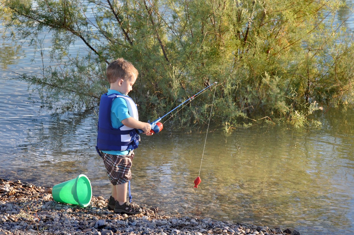 A child is learning how to fish