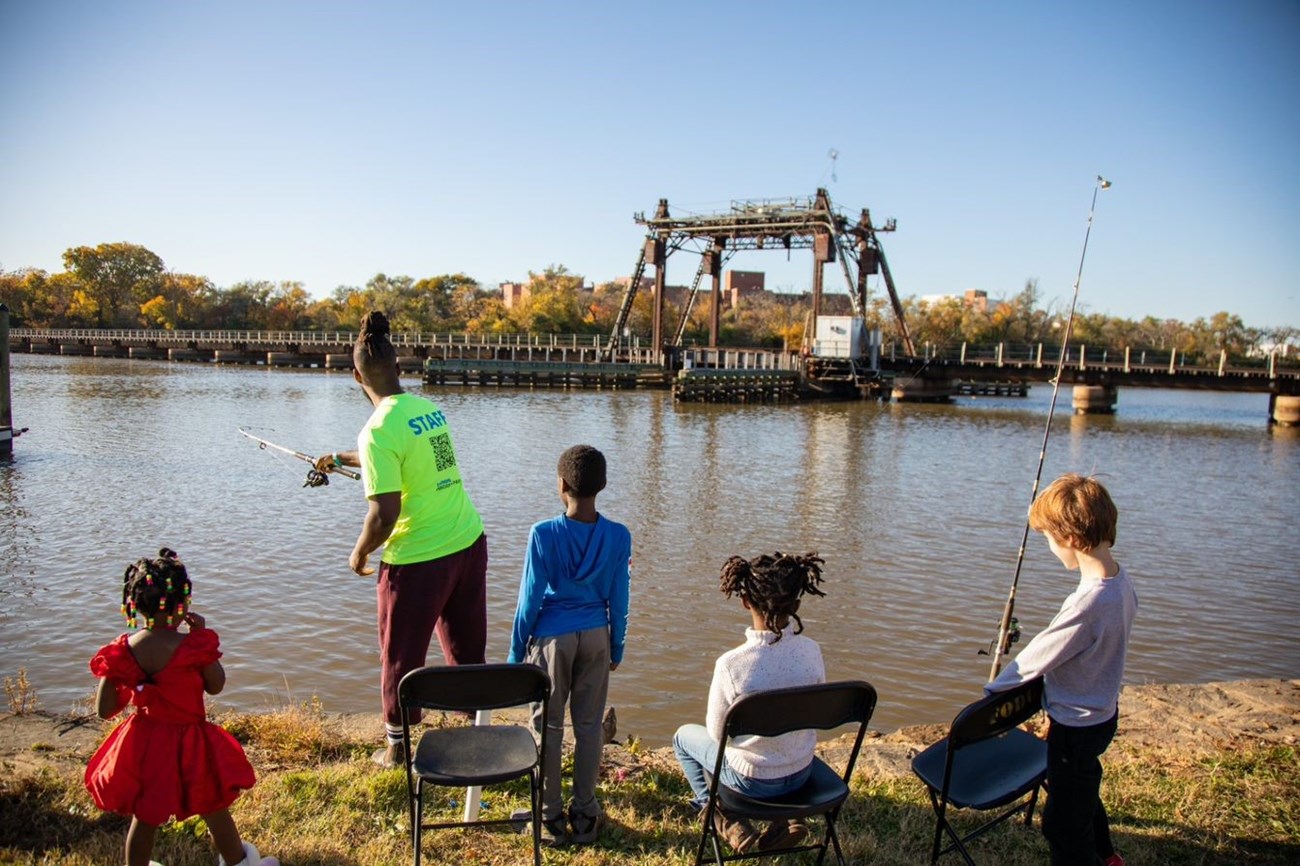 Richard from the Friends of Anacostia Park teaching 4 children how to fish