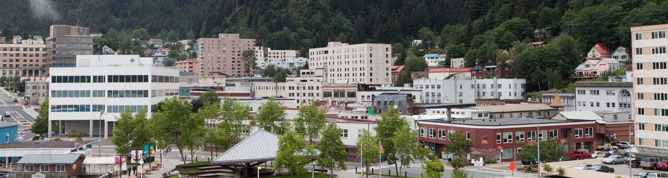 Downtown of city with green mountains behind.