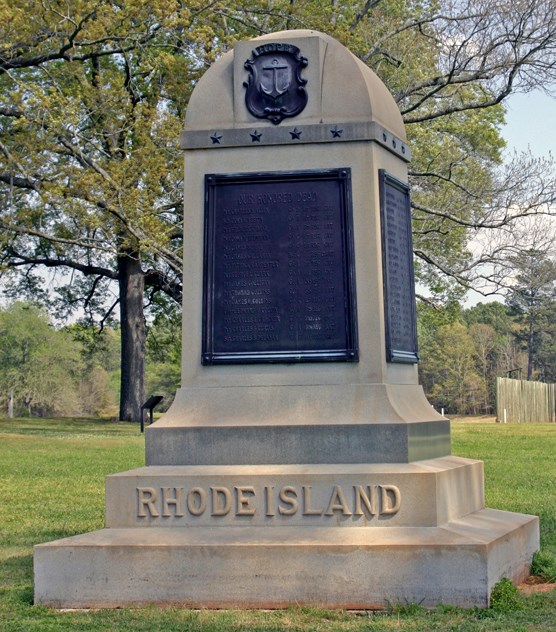 A stone monument with aplaque and the words "Rhode Island." A stone monument with aplaque and the words "Rhode Island."