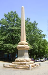 Tall stone monument in the middle of a street. Tall stone monument in the middle of a street.
