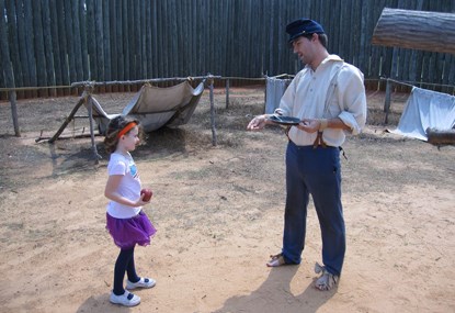 A young girl stands near a Civil War Prisoner A young girl stands near a Civil War Prisoner