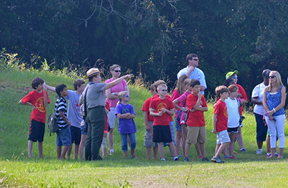 A park ranger directs the attention of students to a feature of the prison site