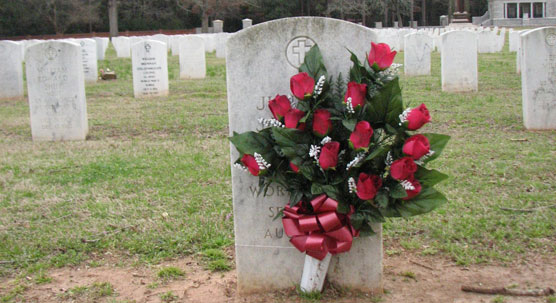 Artificial flowers in front of a grave.