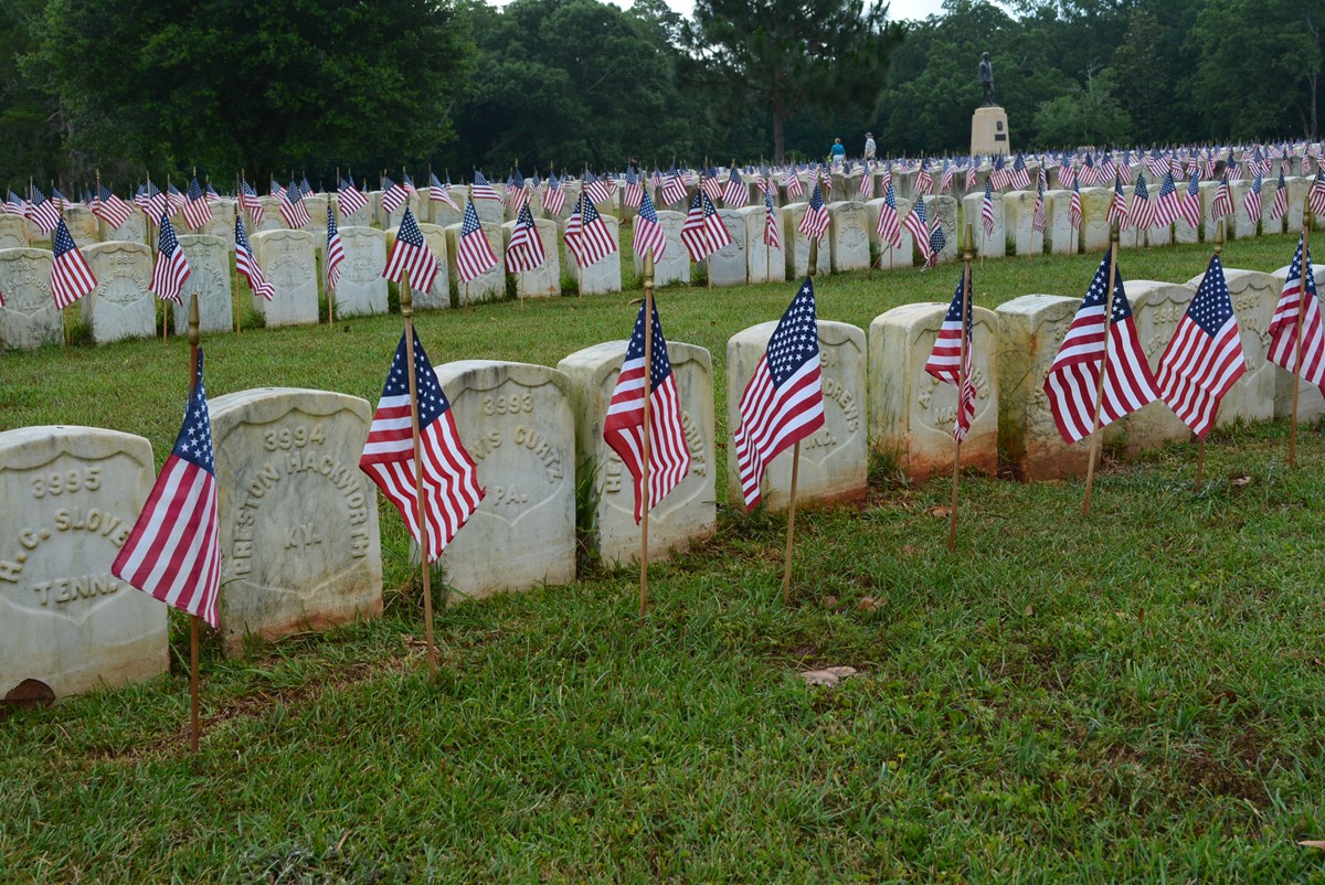 Rows of headstones with small American flags in front of them.