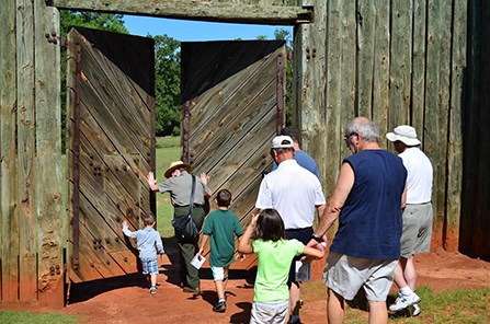 A park ranger leads a group through the reconstructed north gate of the prison.