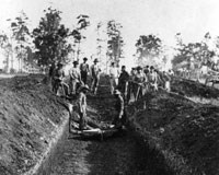 Men standing in a waist-deep burial trench Men standing in a waist-deep burial trench