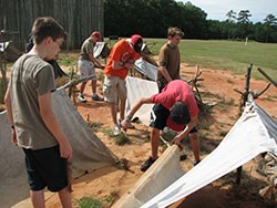 Boy scouts work to assemble canvas shelters Boy scouts work to assemble canvas shelters