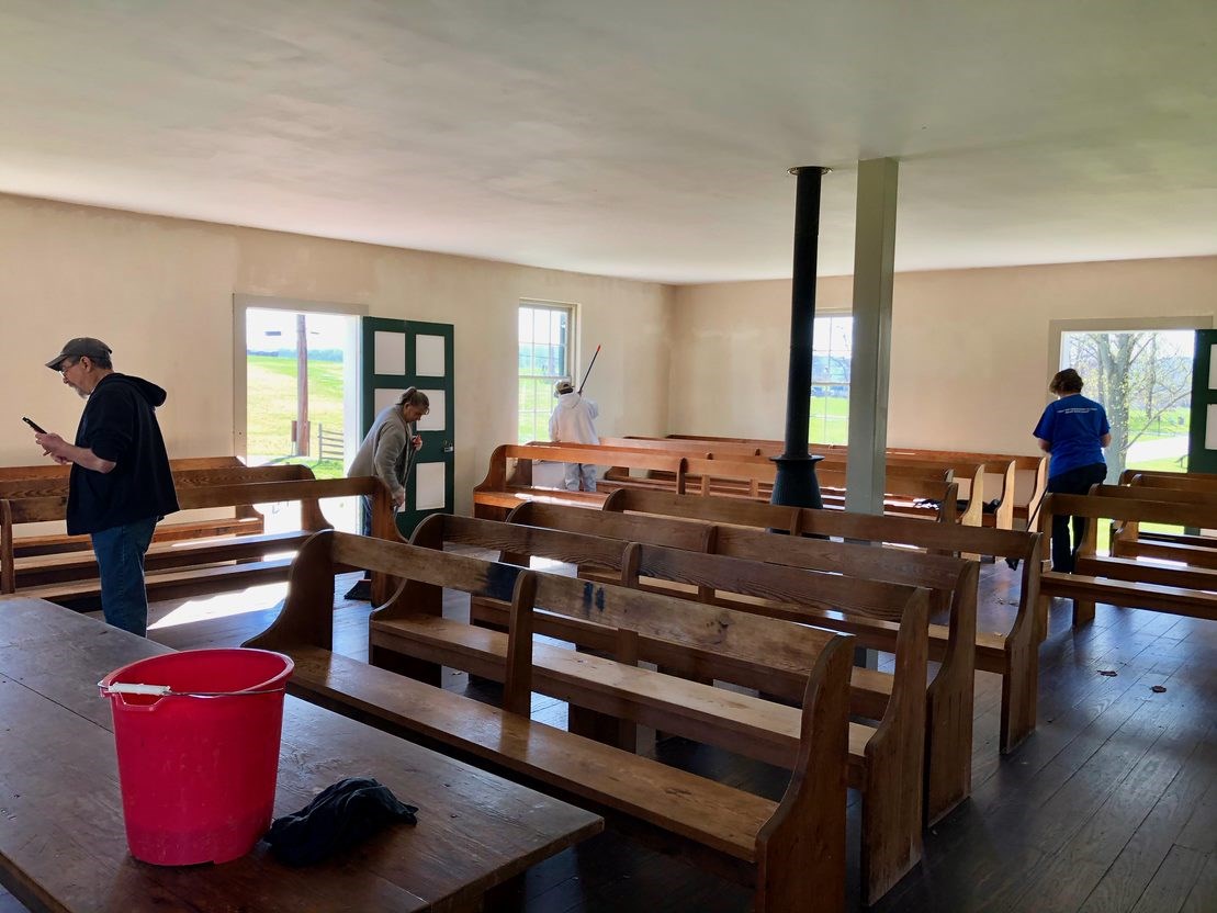 volunteers sweep a building
