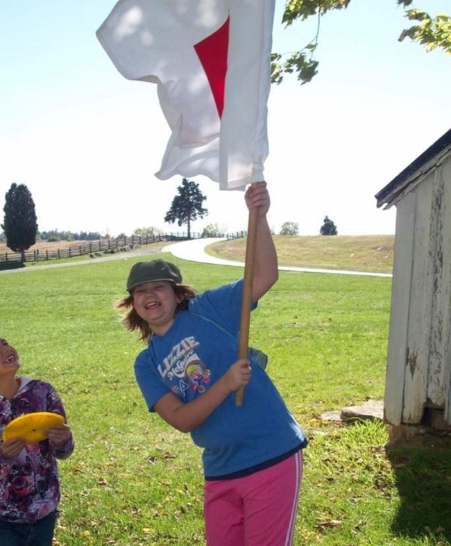 Students signalling messages with flag and cipher disk