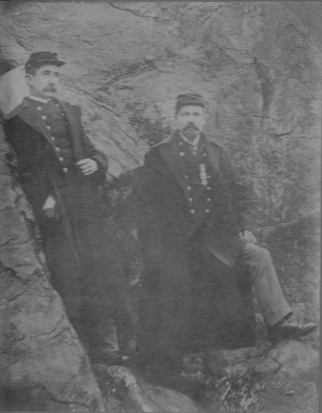 Civil War vets standing near large boulder