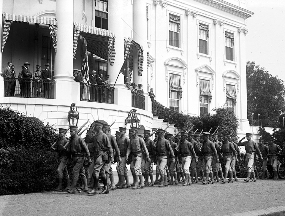 Marines march past the president on the south lawn of the White House
