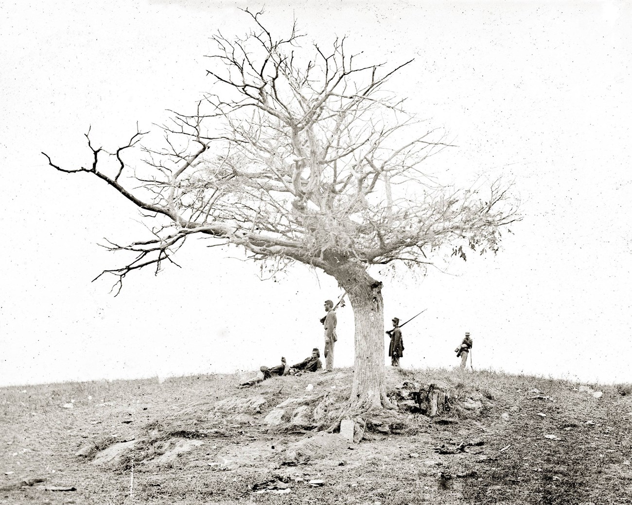 grave on battlefield with solders standing guard