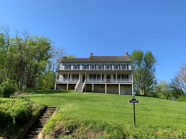 blue two story house on a hill