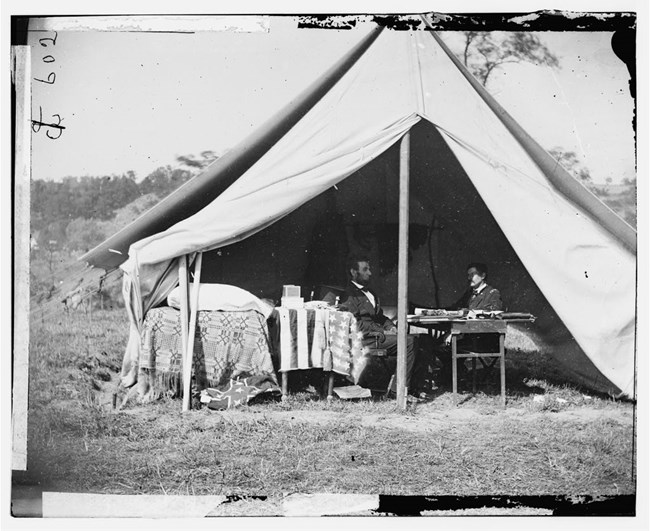 lincoln and mcclellan sitting in a tent