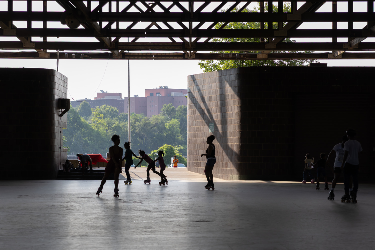 Children hold hands as they roller skate around the rink at Anacostia Park Skating Pavilion during the park’s Late Skate program in Washington, D.C., on June 28, 2025.