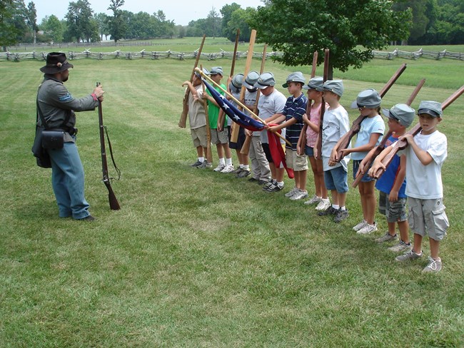 Group of students acting out stacking of arms ceremony