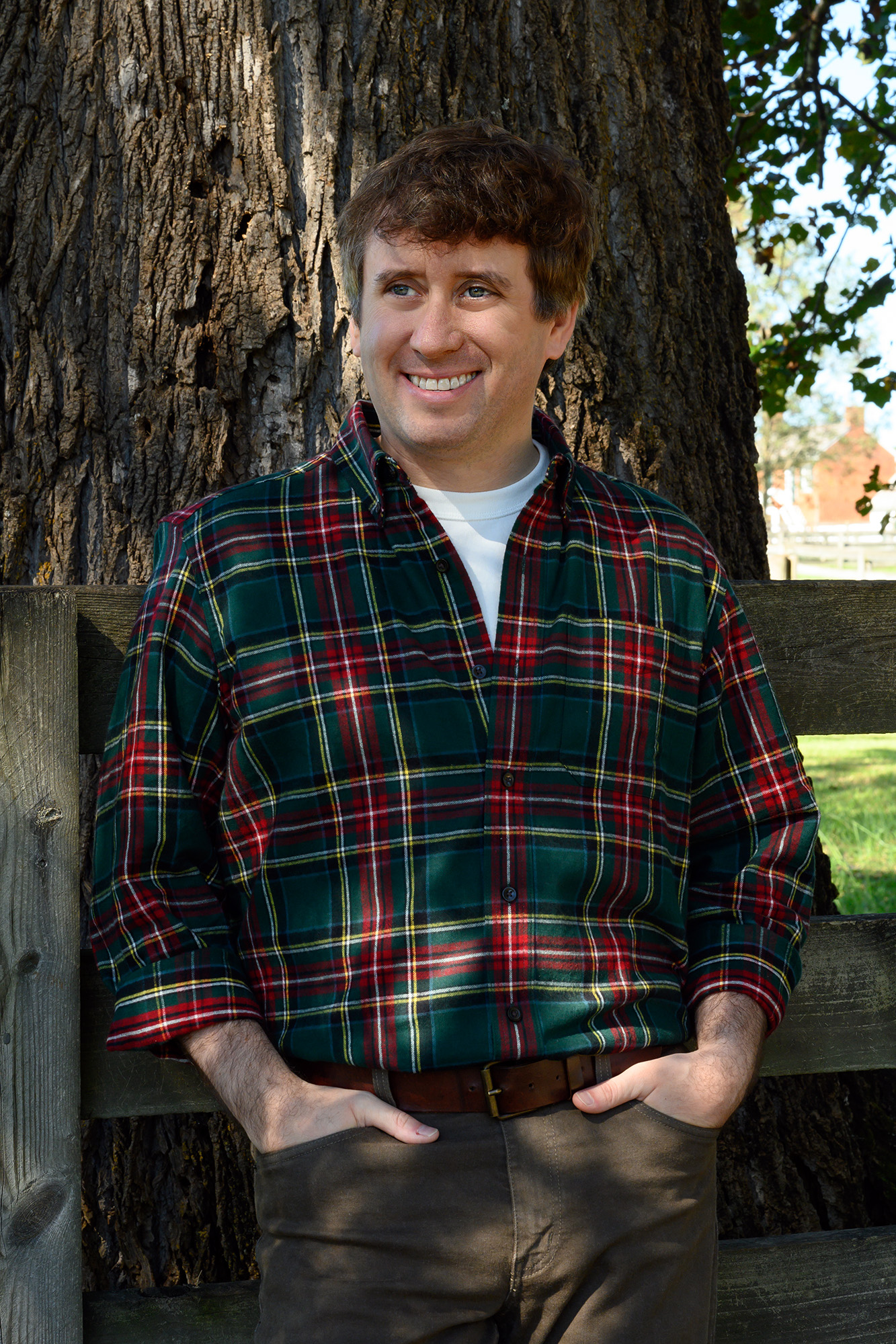 A white man in a plaid shirt poses for a portrait