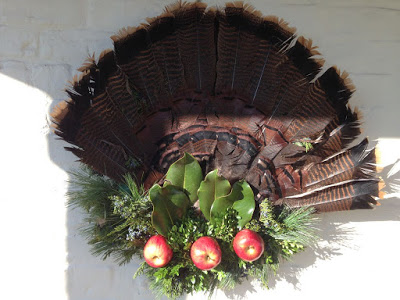 Turkey Wreath Christmas wreath made with turkey feathers, apples, magnolia leaves and pine needles.
