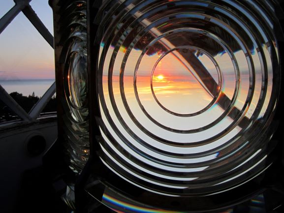 Sunset through a fresnel lens looking over a body of water